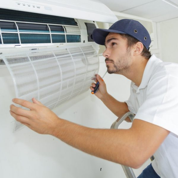 portrait-of-mid-adult-male-technician-installing-split-system-air-conditioning